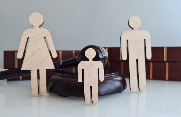 wooden family figure near judge's gavel
