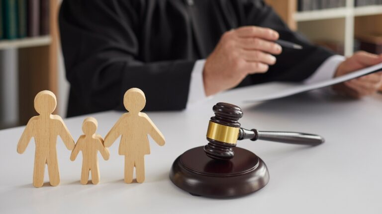 wooden figurines of family with child and judge's gavel