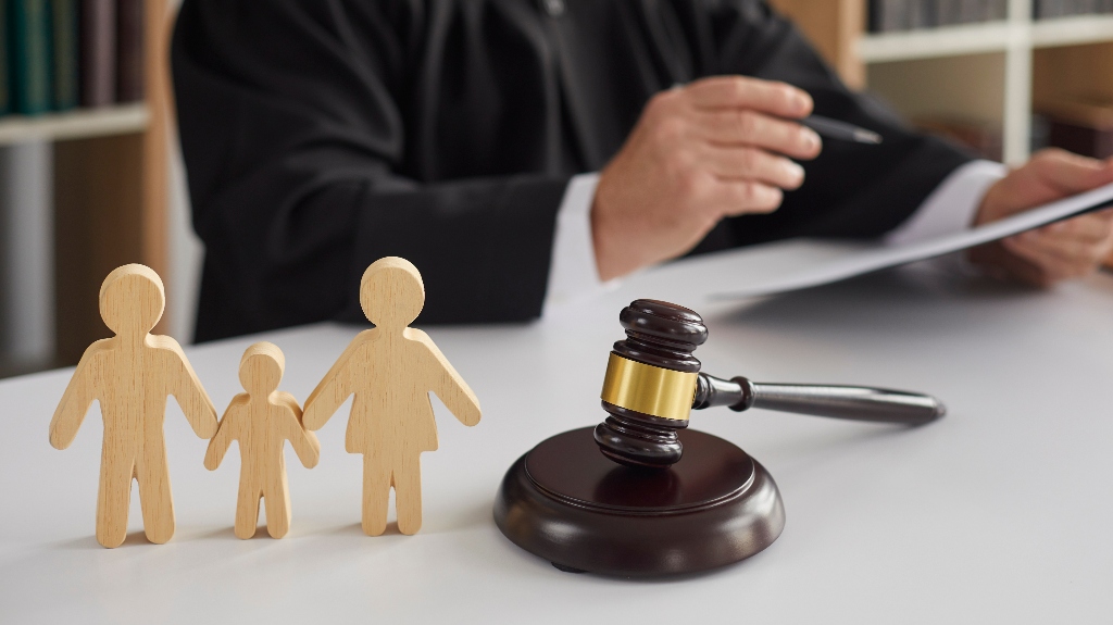 wooden figurines of family with child and judge's gavel