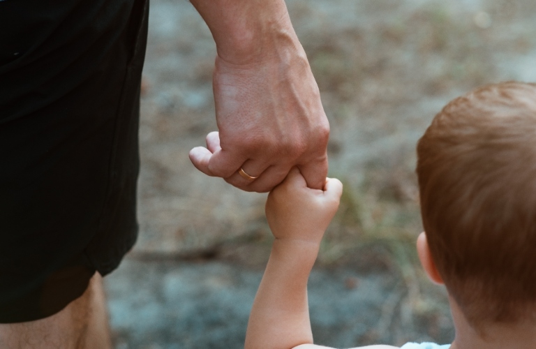 child holding father's hand